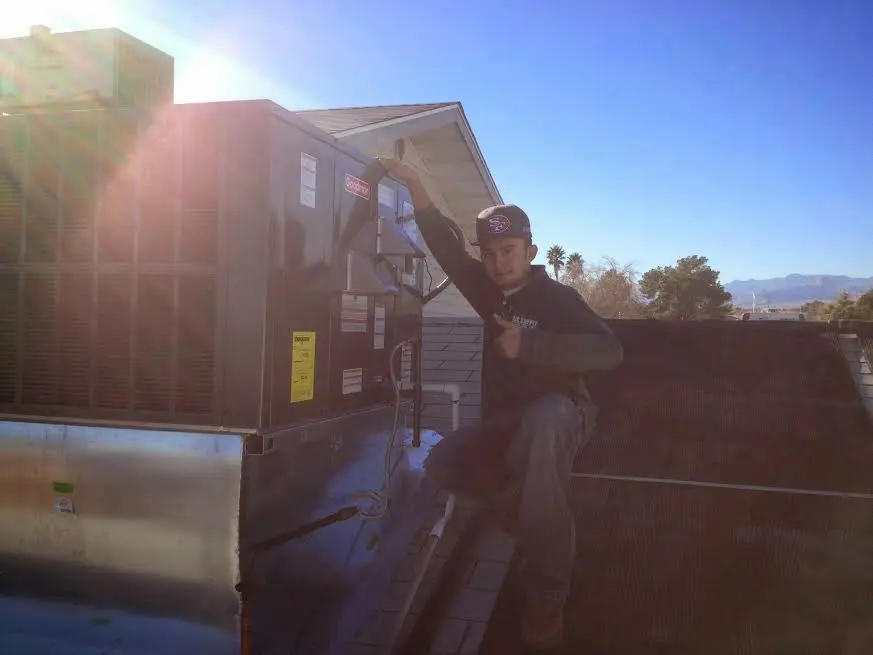 HVAC technician performing Heat Pump Repair on a rooftop unit in Fort Leonard Wood